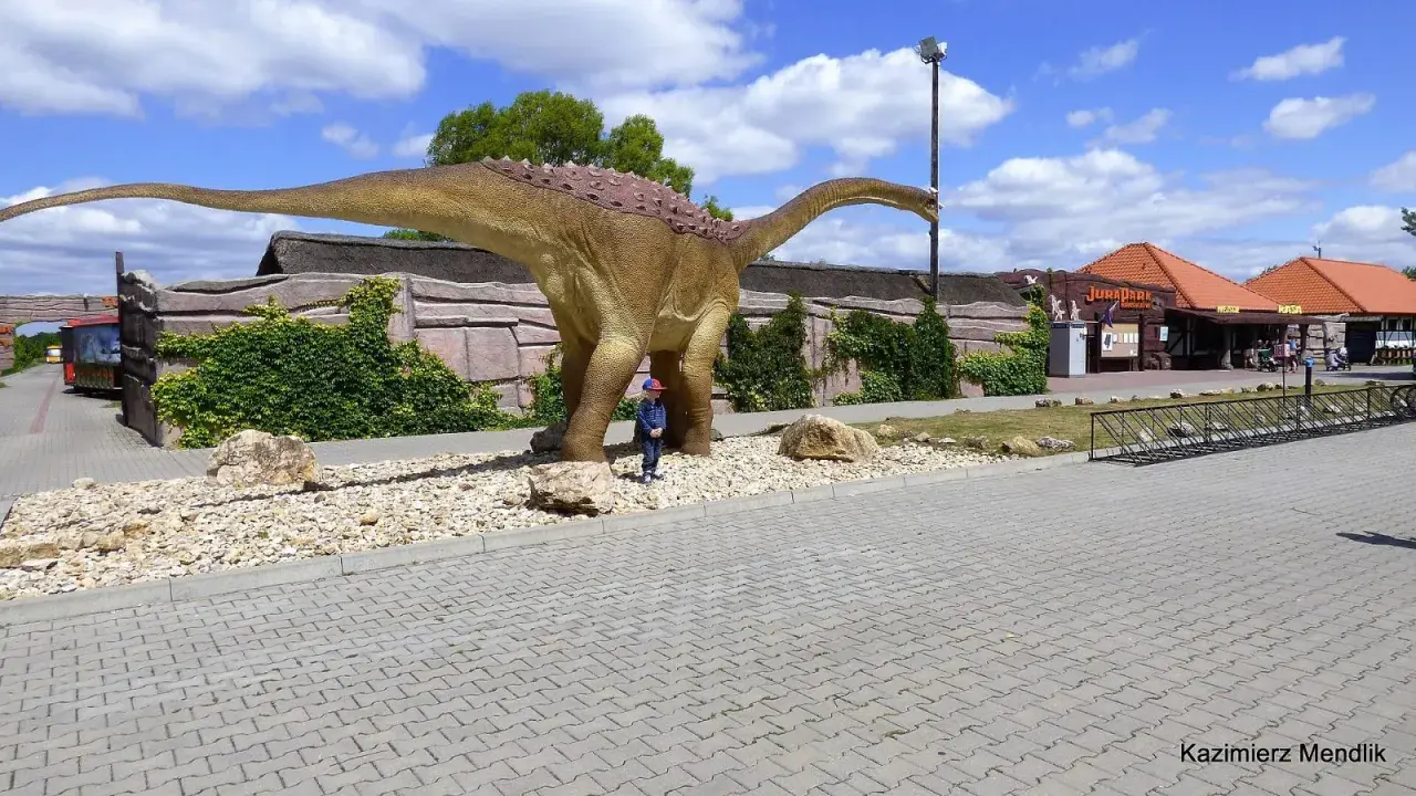 Dziecko podziwia ogromnego dinozaura w JuraParku. Jura Krakowsko-Częstochowska oferuje wspaniałe atrakcje dla dzieci.