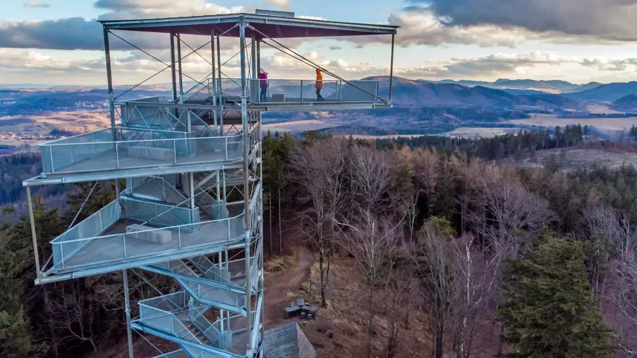 Wieża widokowa na Trójgarbie zaprasza na spacer po szlakach. Dwie osoby podziwiają panoramę z platformy.