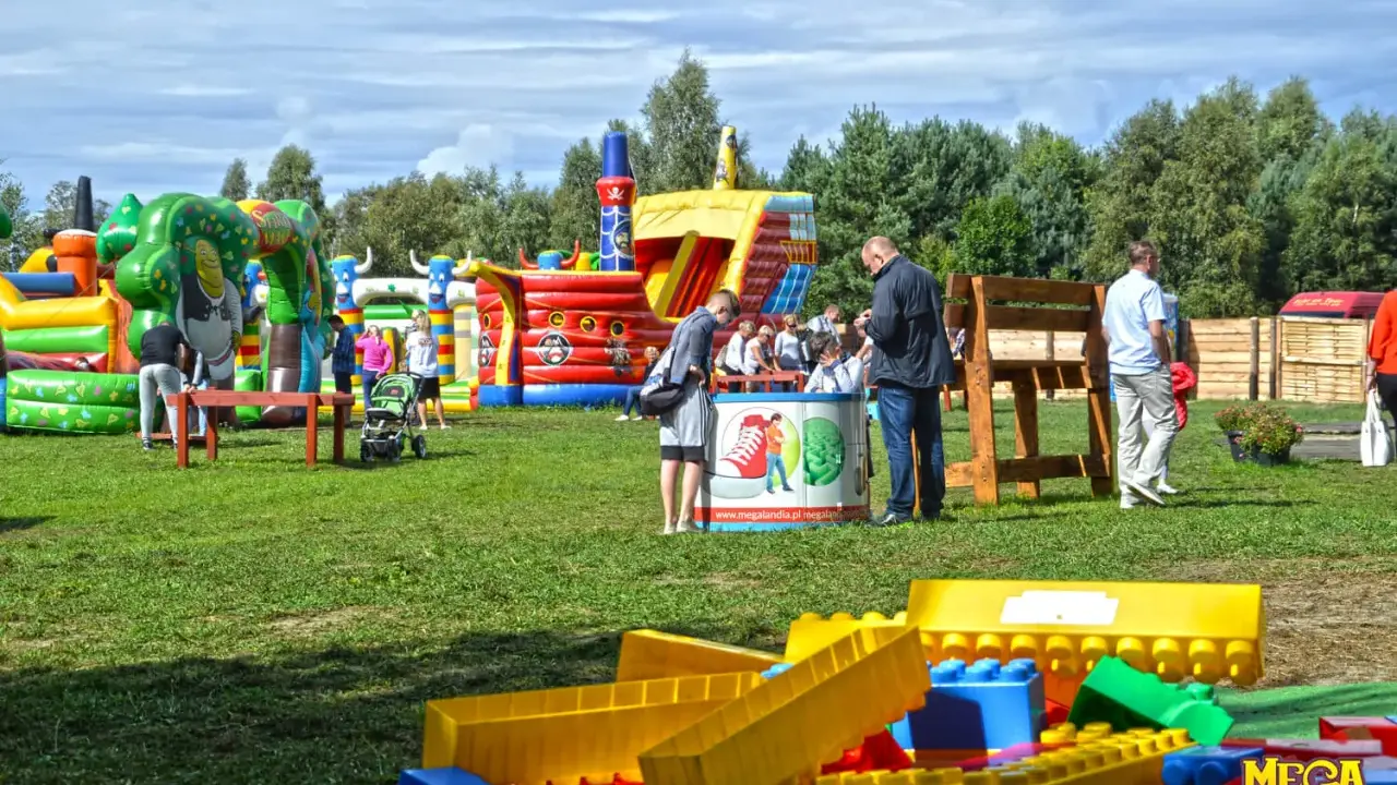 Kolorowe dmuchańce i plac zabaw w Ustce oferują mnóstwo atrakcji dla dzieci. Rodziny cieszą się słońcem i zabawą na świeżym powietrzu.
