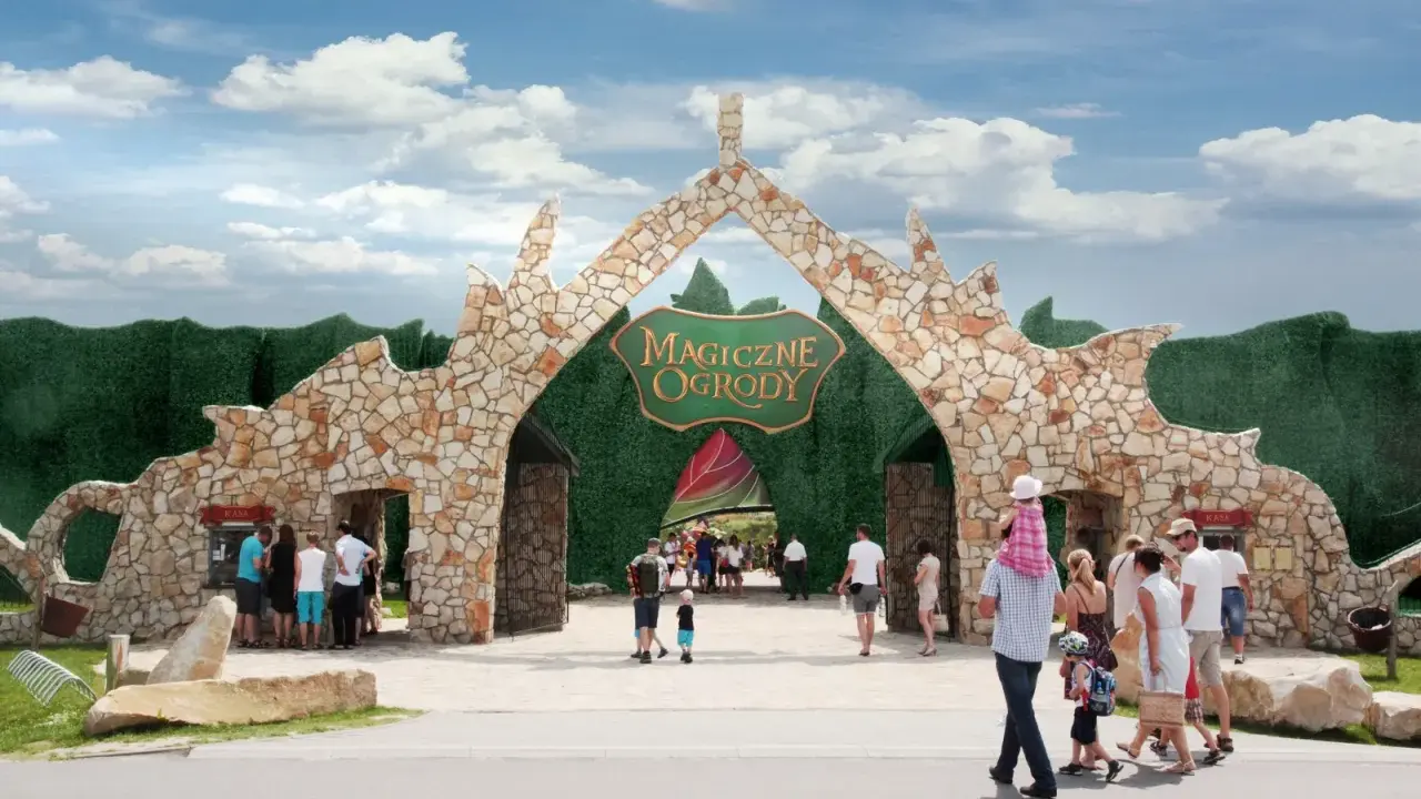 Rodziny wchodzą przez kamienną bramę do Magicznych Ogrodów, szukając atrakcji dla dzieci mazowieckie.