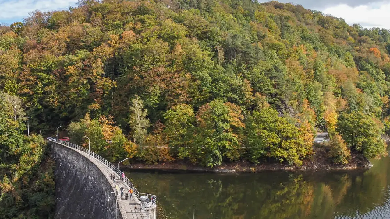 Jesienna panorama gór Sowich z zaporą i jeziorem. W oddali widać malownicze miejscowości.