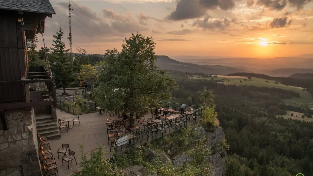 Widok z tarasu restauracji na Górach Stołowych w Czechach o zachodzie słońca.