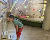 Dziewczynka z zaciekawieniem przygląda się interaktywnej wystawie w muzeum dla dzieci w Krakowie.