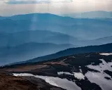 Niesamowite babia góra widoki. Warstwy gór w odcieniach niebieskiego, z ostatnim planem pokrytym śniegiem i zielenią.