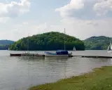Rożnów atrakcje: jezioro z łodziami i żaglówkami, zielone wzgórza, spokojna woda. Idealne miejsce na wypoczynek.
