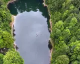 Jeziorko Daisy, otoczone gęstym lasem, skrywa tajemniczą legendę. W jego mrocznych wodach widać dryfujące gałęzie.