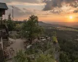 Widok z tarasu restauracji na Górach Stołowych w Czechach o zachodzie słońca.
