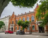 Architektura w Radomiu zachwyca. Czerwona kamienica z ozdobnymi oknami i biały budynek obok to ciekawe radomskie atrakcje.