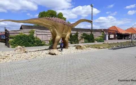Dziecko podziwia ogromnego dinozaura w JuraParku. Jura Krakowsko-Częstochowska oferuje wspaniałe atrakcje dla dzieci.