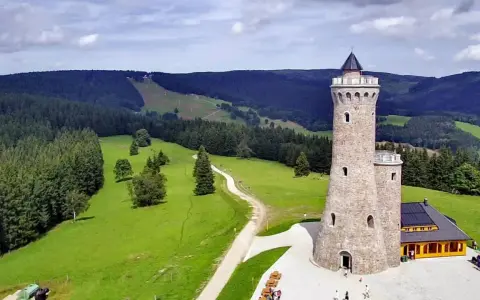 Kamienna wieża widokowa Dalimilova rozhledna góruje nad zielonymi wzgórzami i lasami.
