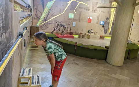 Dziewczynka z zaciekawieniem przygląda się interaktywnej wystawie w muzeum dla dzieci w Krakowie.