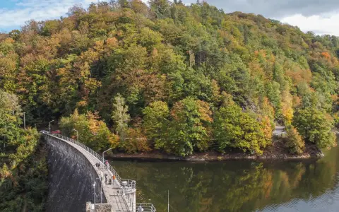 Jesienna panorama gór Sowich z zaporą i jeziorem. W oddali widać malownicze miejscowości.