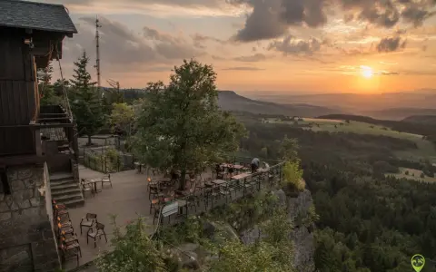Widok z tarasu restauracji na Górach Stołowych w Czechach o zachodzie słońca.