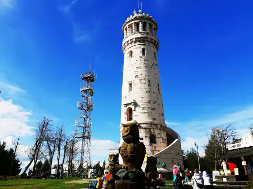 Wieża widokowa i maszt telekomunikacyjny na tle błękitnego nieba. W oddali widać góry Sowie.