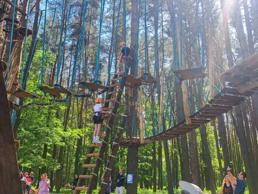 Park linowy w Białymstoku oferuje emocjonujące atrakcje dla dorosłych. Wspinaczka po drzewach i pokonywanie mostków to świetna zabawa.