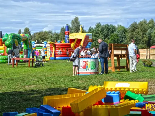 Kolorowe dmuchańce i plac zabaw w Ustce oferują mnóstwo atrakcji dla dzieci. Rodziny cieszą się słońcem i zabawą na świeżym powietrzu.