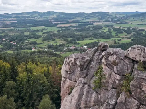 Skalnik szczyt z widokiem na dolinę, lasy i pagórkowaty krajobraz.