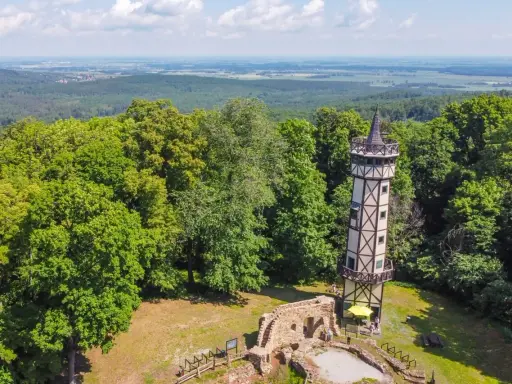 Wieża widokowa i ruiny zamku na wzgórzu wśród zielonych lasów, malownicze góry koło Wrocławia.