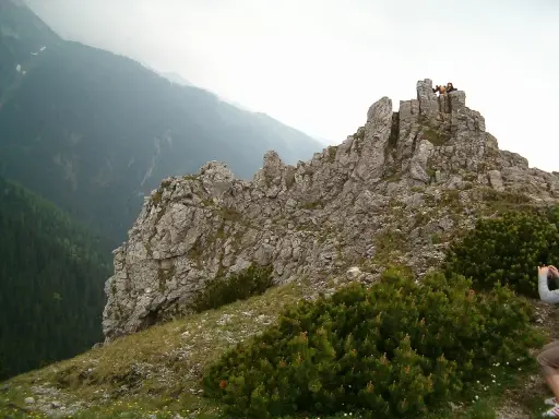 Sarnia góra wita turystów skalistym szczytem. W oddali widać zalesione doliny.