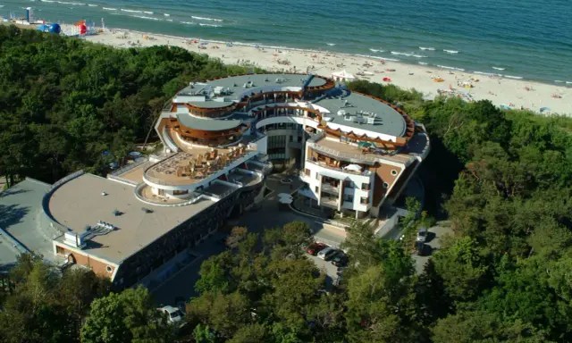 Nowoczesny hotel nad morzem, z tarasami i widokiem na plażę. Idealne miejsce na rodzinne wakacje, oferujące liczne jastarnia atrakcje dla dzieci.