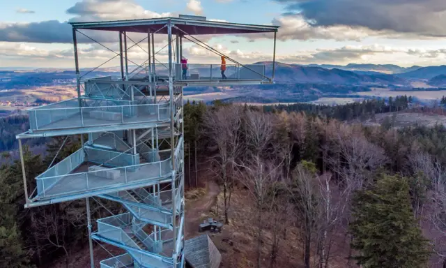 Wieża widokowa na Trójgarbie zaprasza na spacer po szlakach. Dwie osoby podziwiają panoramę z platformy.