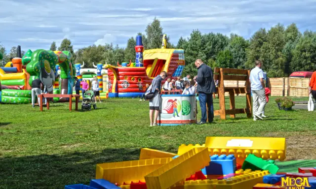 Kolorowe dmuchańce i plac zabaw w Ustce oferują mnóstwo atrakcji dla dzieci. Rodziny cieszą się słońcem i zabawą na świeżym powietrzu.