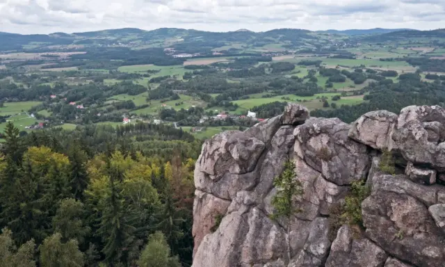 Skalnik szczyt z widokiem na dolinę, lasy i pagórkowaty krajobraz.
