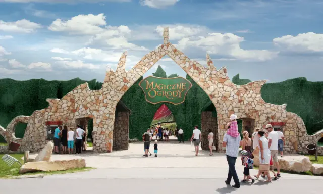 Rodziny wchodzą przez kamienną bramę do Magicznych Ogrodów, szukając atrakcji dla dzieci mazowieckie.