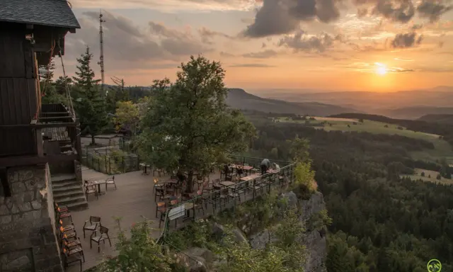 Widok z tarasu restauracji na Górach Stołowych w Czechach o zachodzie słońca.