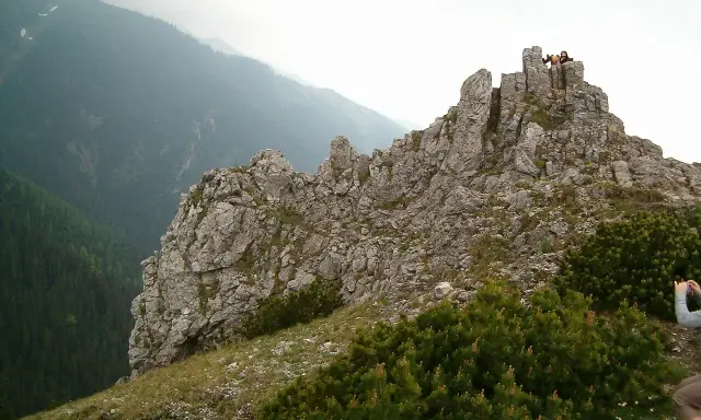 Sarnia góra wita turystów skalistym szczytem. W oddali widać zalesione doliny.