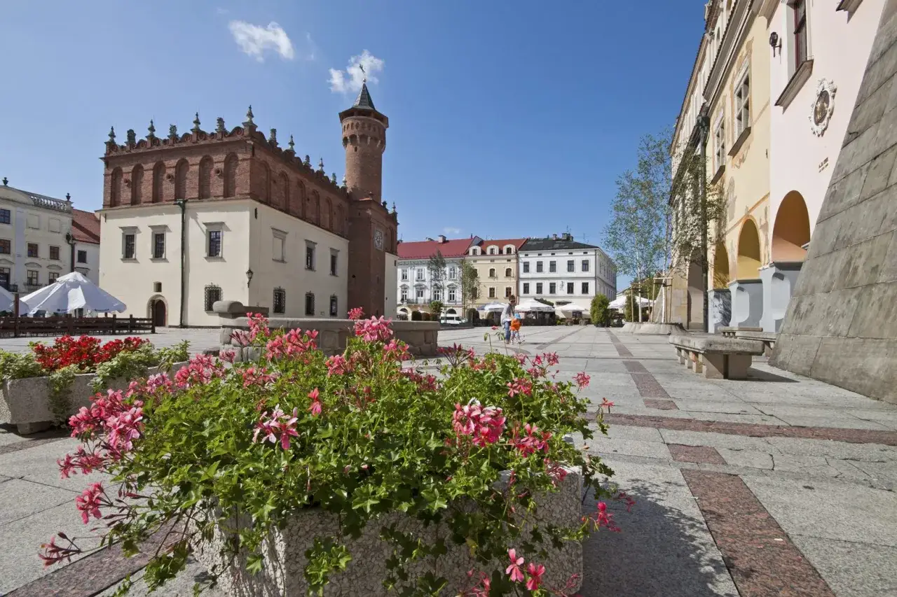 Tarn&oacute;w atrakcje: Rynek z ratuszem i kwitnącymi pelargoniami, idealne miejsce na spacer.