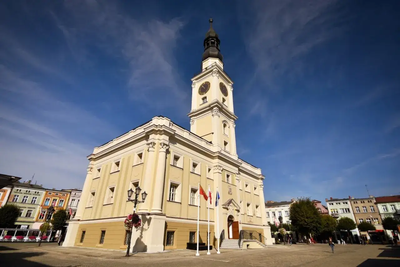 Ratusz w Lesznie, jedna z gł&oacute;wnych atrakcji miasta, z wieżą zegarową i kolorowymi kamienicami w tle.