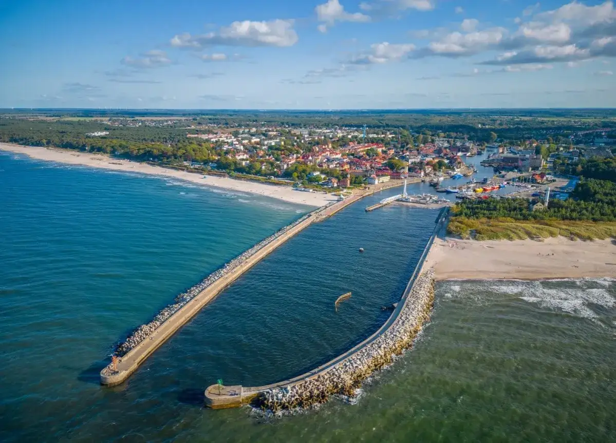 Widok na port w Ustce z falochronami i plażą. Idealne miejsce na wakacje, mn&oacute;stwo ustka atrakcje dla dzieci.