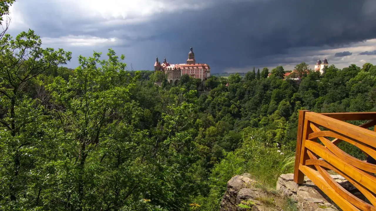 Zamek Książ góruje nad bujną zielenią Książańskiego Parku Krajobrazowego. Burzowe chmury zapowiadają deszcz.