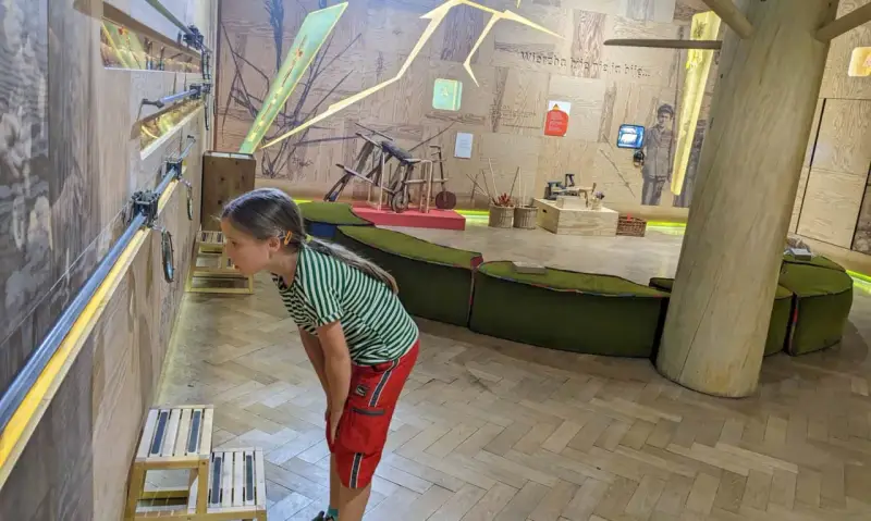 Dziewczynka z zaciekawieniem przygląda się interaktywnej wystawie w muzeum dla dzieci w Krakowie.