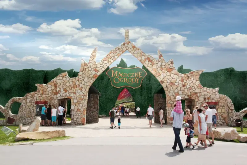 Rodziny wchodzą przez kamienną bramę do Magicznych Ogrodów, szukając atrakcji dla dzieci mazowieckie.